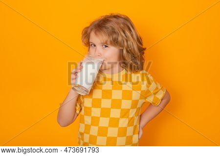 Child With Glass Of Milk On Studio Yellow Background. Kid With Milk Moustache. Fun Portrait Of Cute 