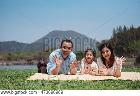 Happy Family In The Nature Travel. Family On Weekend Playing Together In The Meadow With River Paren