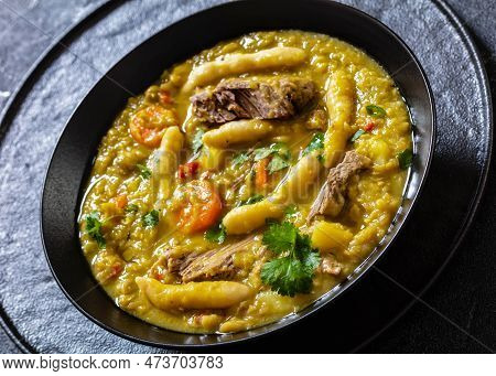 Gungo Peas, Pigeon Peas Soup With Dumplings And Beef In Black Bowl On Concrete Table, Jamaican Cuisi