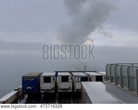 Transport Trucks Aboard Stena Line Ferry. Smoke From The Ship And Clouds In Background. Hook Of Holl