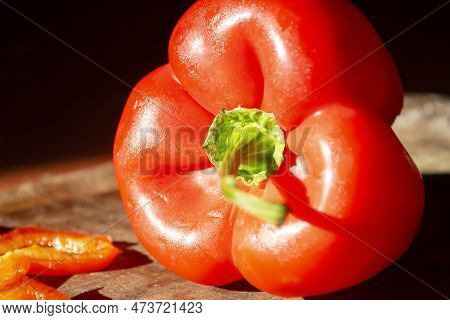 Red Bell Pepper On A Wooden Board. Bright, Healthy Vegetables. A Constrate Photo Of A Bell Pepper Wi