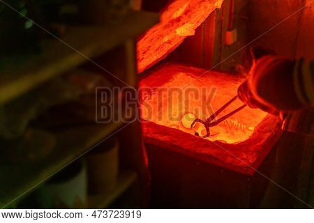 Potter Takes Out The Pottery With Tongs From A Red-hot Electric Muffle Furnace For Firing