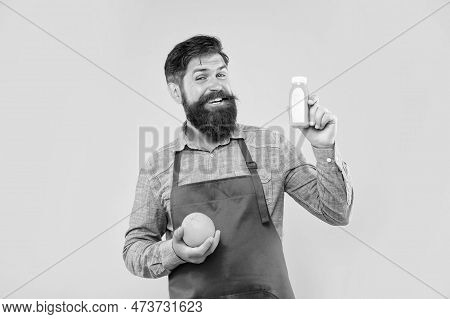Happy Man In Apron Holding Orange And Juice Bottle Yellow Background, Barkeeper
