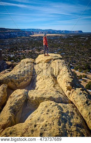 Woman Standing On Top Of Sandstone Formations At El Malpais National Monument, New Mexico.