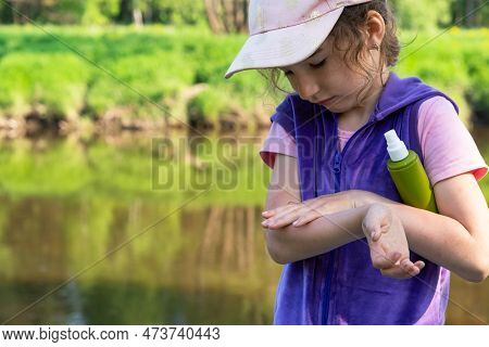 Girl Uses A Remedy For Mosquitoes And Biting Insects In Nature. Protection Of The Skin From Tick Bit