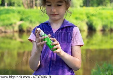 Girl Uses A Remedy For Mosquitoes And Biting Insects In Nature. Protection Of The Skin From Tick Bit