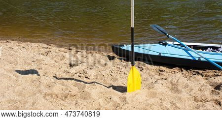 Tourist Canoes With Paddles Stand On The River Coast In Summer On A Water Hike. Rafting On Inflatabl