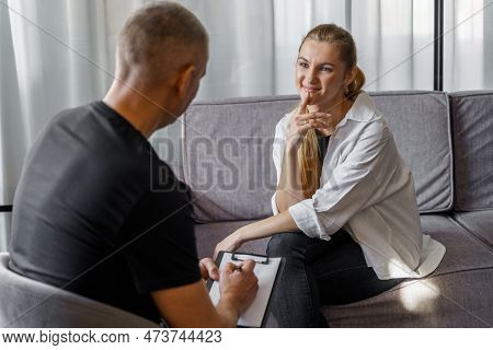 A Male Psychologist At A Consultation Is Talking To A Woman Who Is Smiling. Psychology And Psychosom