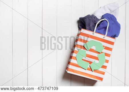 Childrens Clothes In Shopping Bag With A Recycling Symbol. Second Hand, Donation Clothing Concept, C