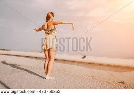 Woman Summer Dance. Silhouette Of A Happy Woman Who Dances, Spins And Raises Her Hands To The Sky. A