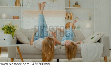 Caucasian Mother With Long Hair Lying On Couch In Living Room With Little Girl Daughter Child Lie Up
