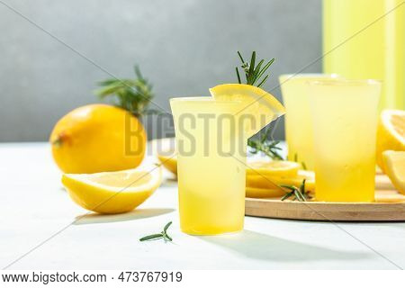 Homemade Lemon Liqueur Limoncello With Rosemary And Lemons On A Light Background. Place For Text,