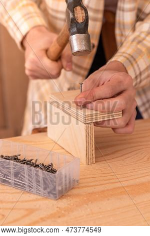 Handyman Hammering Nail Into Wooden Plank. Crop Anonymous Male Woodworker Using Hammer To Drive Nail