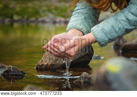 Close-up Of A Womans Hand Pouring Water From Her Palms While Trying To Drink From A Clean Water Sour