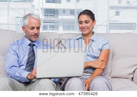 商务人士看着笔记本电脑和 staffroom 在微笑