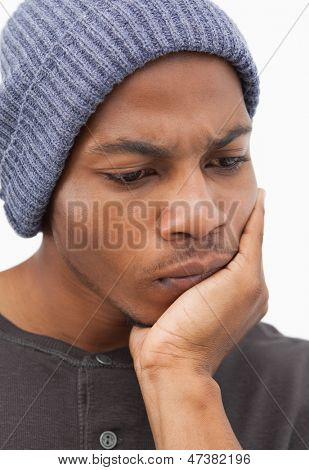 ชายหมวก beanie มอง thougtful บนพื้นหลังสีขาว