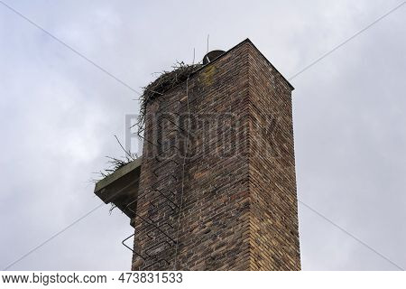 An Old Red Brick Chimney With A Stork S Nest On Top. A Huge Brick Chimney With Steel Clamps And A Li