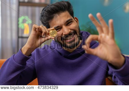 Indian Man Freelancer Holding Gold Coin Successful Developer Programmer. Ok. Hindu Guy Stock Trader 