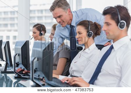 Sorridente manager aiutando chiamata centro agente con un auricolare