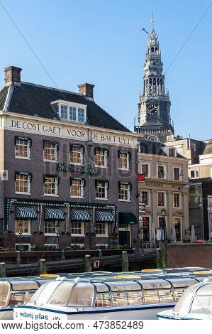 Amsterdam, Netherlands - May 5, 2013: These Are Historic Houses In Damrak Harbor And The Belfry Of T
