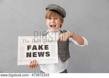 Newsboy Shouting Against Grunge Wall Background. Boy Selling Fake News