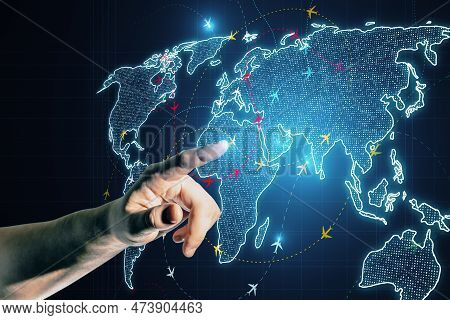 Close Up Of Hand Pointing At Glowing Digital Map With Ariplane Connections On Dark Background. Fligh