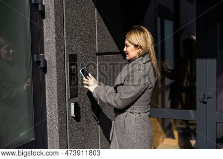 Smart Home Concept - Close Up Of Woman Use Mobile Phone To Open Electronic Lock
