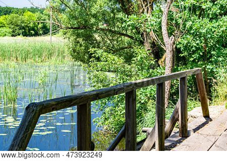 Beautifully Standing Old Wooden Bridge Over River In Colored Background Close Up