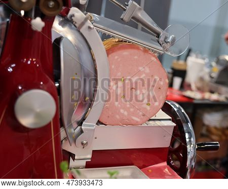 Mortadella Ready To Be Cut On A Professional Slicer