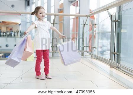Jovem carregada de sacolas de papel