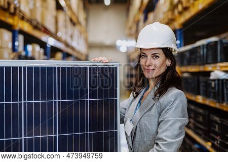 Portrait Of Manager Holding A Solar Panel In A Warehouse.