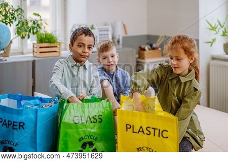 Children Separating Rubish In To Three Bins.