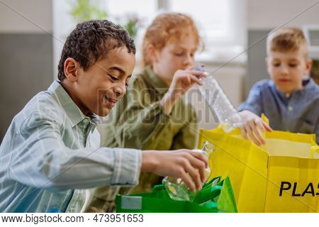 Children Separating Rubish In To Three Bins.
