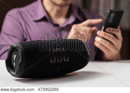 Dnioro Ukraine. 27 January 2023: Man Holding Smartphone And Use Portable Music Speaker Jbl Charge 5.