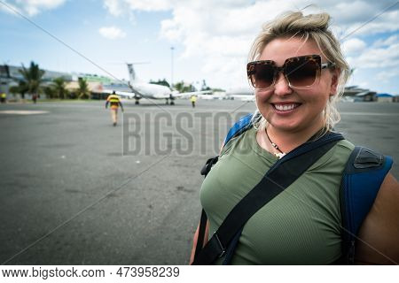 Happy Smiling Woman On The Tarmac Of The Zanzibar Airport In Tanzania, Just After Landing