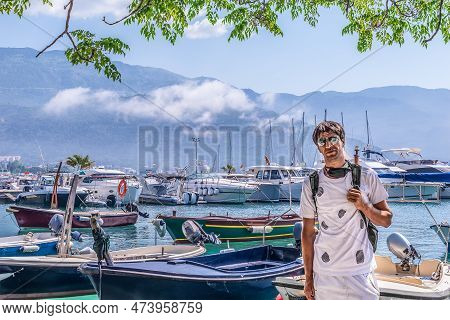 Portrait Of A Young Man Against Boats In The Port Of Dukley Marina In Budva, Montenegro. The Adult G