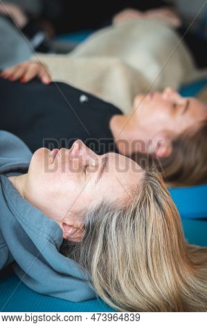 Vilnius, Lithuania - March 26 2023: Beautiful Blond Hair Caucasian Girls Lying On A Mat And Touching