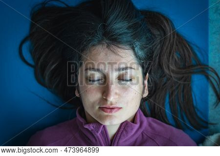 Vilnius, Lithuania - March 26 2023: Beautiful Asian Girl Lying On A Mat And Touching Her Breast And 
