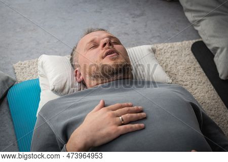 Vilnius, Lithuania - March 26 2023: Boy During A Yoga Class Lying On A Mat, Breathing And Meditating