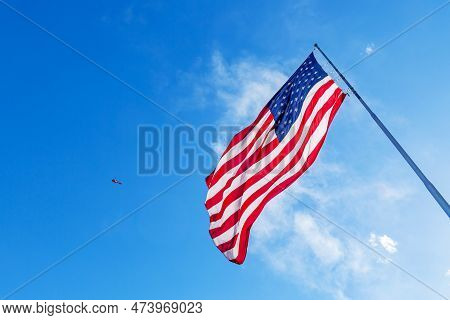 American Flag Blowing In The Wind With A Blue Sky Background. Usa American Flag. Waving United State