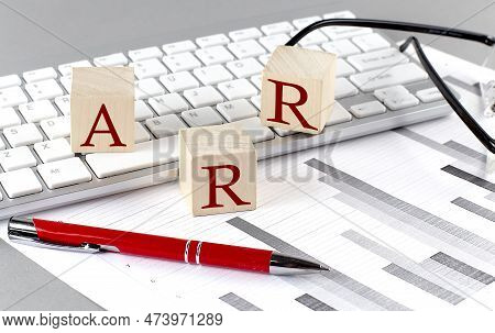Arr Written On Wooden Cube On The Keyboard With Chart On Grey Background