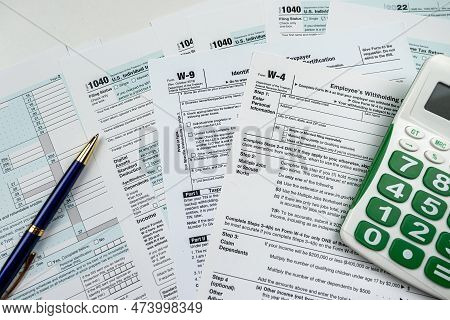Calculator On Blank 1040 W4 W9 Tax Form 2022, Taxation Concept