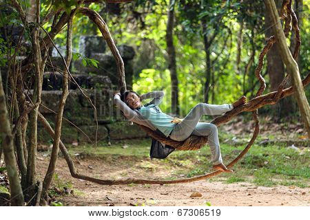 SIEM REAP, CAMBODIA, DECEMBER 03 : Unidentified Cambodian girl is lying on a vine around the temple of Banteay Kdei  near Siem Reap, Cambodia on December 03, 2012