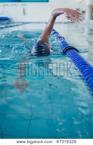 Fit swimmer doing the front stroke in the swimming pool at the leisure center