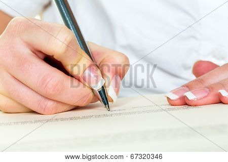a woman signs a contract or a will with a fountain pen.