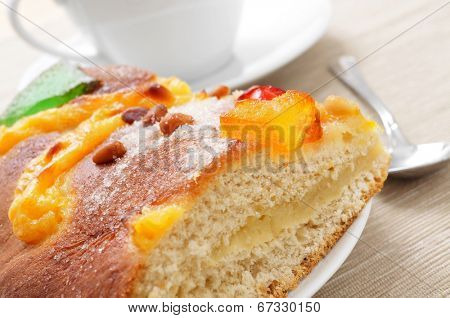 a piece of coca de Sant Joan, a typical sweet flat cake from Catalonia, Spain, eaten on Saint Johns Eve, and a cup of hot chocolate in the background