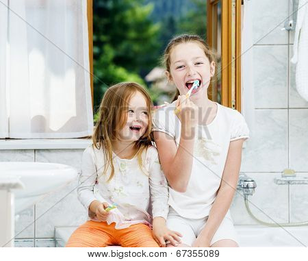 Two Sisters Cleaning The Teeth Together