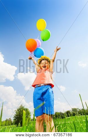 Happy girl with balloons wearing flower circlet