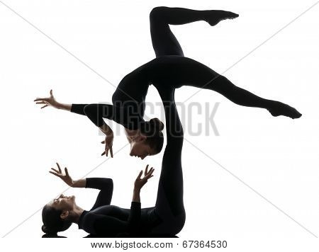 two women contortionist practicing gymnastic yoga in silhouette on white background