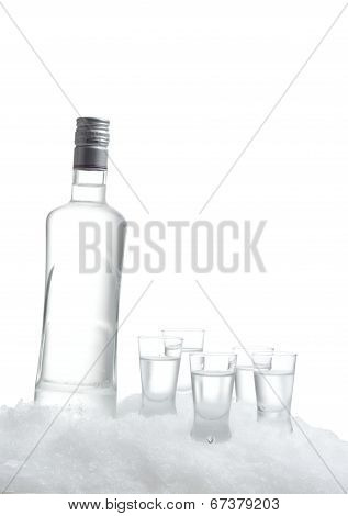 Bottle Of Vodka With Glasses Standing On Ice On White Background